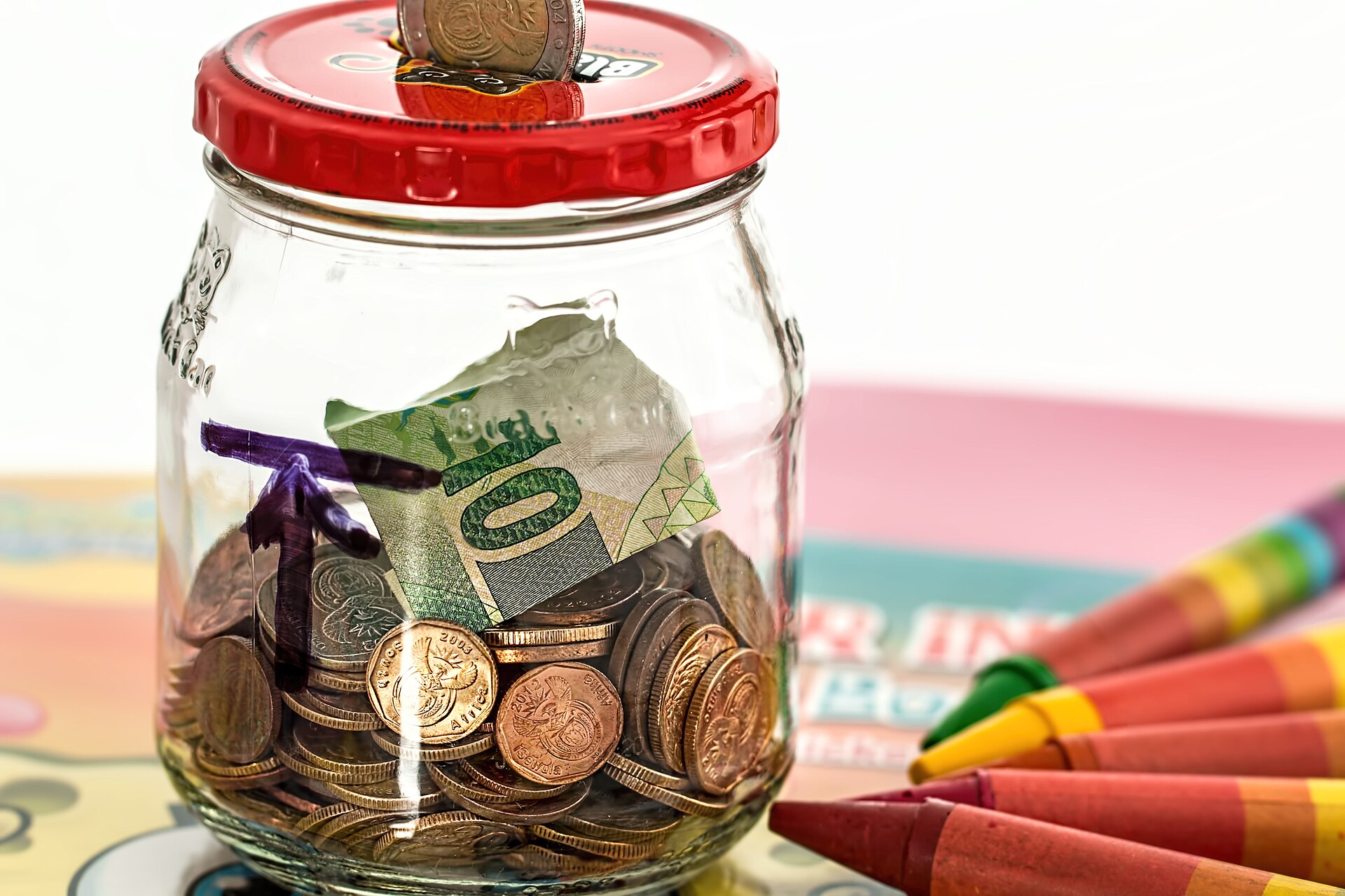 Glass jar of coins representing an emergency fund savings cushion