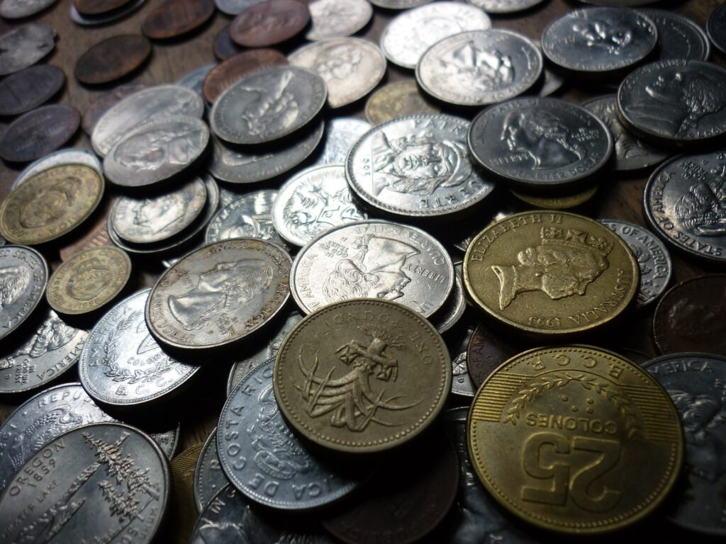 Mixed coins representing a diversified portfolio in index funds vs. ETFs